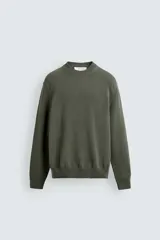 Sweater de punto negro de corte regular fit, confeccionado en algodón con cuello redondo, manga larga y acabados en rib.