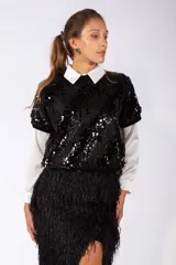 Remera de manga corta con diseño de lentejuelas en color rosado, cuello redondo y ajuste holgado.