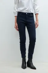 Pantalón de denim negro, corte slim, con cintura media y cierre frontal con botón y cremallera.