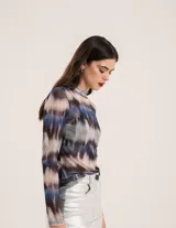 Polera de tul elastizado con cuello alto y mangas largas. Diseño con estampado abstracto en tonos azul, marrón y gris.