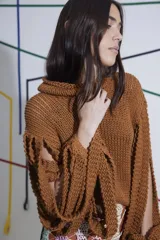 Sweater tejido a mano color marrón, con cuello alto y mangas con aberturas.