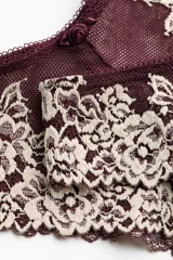 Pack de dos bombachas tipo brazilian de tiro bajo, confeccionadas en malla bordó con encaje floral en tonos beige y bordó. Presentan cintura en V y detalle de pequeños moños decorativos en la parte frontal.