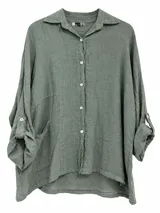 Camisa de lino color verde seco, de corte oversize, con mangas largas arremangables mediante presilla y botón, cuello camisero, cierre frontal de botones y un bolsillo aplicado en el frente.
