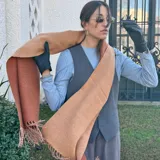 Bufanda de lana color azul marino con flecos en los extremos.