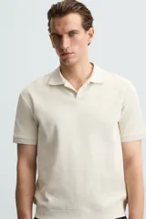 Polo de manga corta color verde oliva, con cuello solapa y abertura frontal tipo polo. Presenta una textura acanalada vertical y un calce regular.