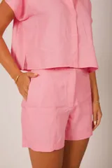 Short de lino verde lima, de tiro alto, con trabillas para cinto y bolsillos laterales.