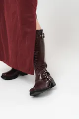 Falda larga color borgoña, confeccionada en tela suave con acabado tipo piel de durazno y cierre invisible lateral.