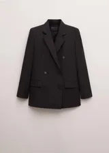 Blazer de corte sastre y diseño cruzado, con cierre de botones frontales, solapas clásicas y bolsillos laterales con solapa. Presenta una estructura entallada y hombros definidos.