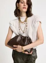 Cartera tipo cubo de Le Lis Blanc, color chocolate, con cierre superior mediante cordón ajustable y herrajes metálicos dorados. Cuenta con una correa larga ajustable para llevar al hombro o cruzada.