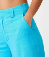 Pantalón pantalona de lino color celeste, de tiro alto, con bolsillos laterales y aberturas frontales en el ruedo.