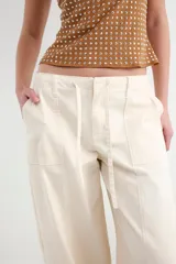 Pantalon cargo color beige de corte recto, con bolsillos laterales y cordón ajustable en la cintura.