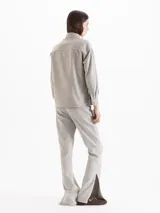 Pantalón Cuore de gabardina en tono gris cemento, con silueta ajustada en la cintura y pierna semi oxford con tajos laterales en el ruedo. Incluye botón metálico dorado con forma de corazón en el frente y pasadores.