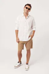 Camisa de manga larga para hombre, color azul claro jaspeado, con cuello clásico y botones blancos. Corte ajustado (slim fit).