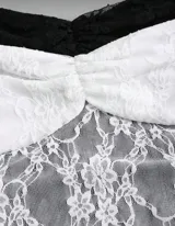 Top tipo corset de encaje floral, disponible en negro y blanco. Presenta un diseño ajustado al cuerpo con escote corazón fruncido y tirantes finos tipo halter ajustables.