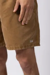 Short de baño de corte relajado en color gris azulado con efecto lavado. Cuenta con cintura elastizada con cordón ajustable, bolsillos laterales y una pequeña etiqueta decorativa en el ruedo.