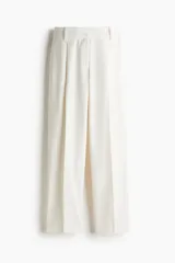 Pantalón sastrero de tiro alto con pinzas, corte holgado y piernas rectas. Presenta cierre frontal con botón y corchete ocultos, bolsillos laterales discretos y bolsillos traseros decorativos.