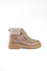 Bota de cuero color marrón con puntera y empeine de gamuza color beige. Interior forrado en piel sintética color beige. Cierre con tira de velcro. Suela de goma con dibujo.