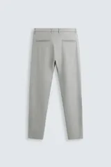 Pantalón de corte slim fit confeccionado en tejido elástico, con cintura elástica, cierre frontal con cremallera y botón, bolsillos laterales y bolsillos traseros de vivo.