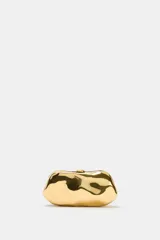 Bolso tipo clutch rígido con acabado metálico dorado y diseño de superficie irregular. Cuenta con cierre superior tipo clip y cadena metálica extraíble para usar como bandolera.