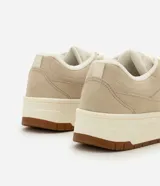 Championes Satinato de PU texturizado símil suede, color beige, con suela tipo caja y base tractorada. Cuentan con cierre de cordones y diseño de recortes en la capellada.