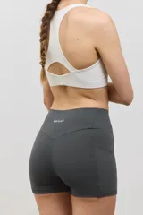 Minishort deportivo de tiro alto con bolsillos laterales, confeccionado en tejido elastizado de compresión media.