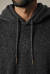 Hoodie de algodón color negro carbón con efecto garment washed, capucha con cordones ajustables y un sutil bordado en el pecho.