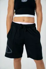 Short negro oversize con logo triangular estampado en gris en la pierna izquierda.
