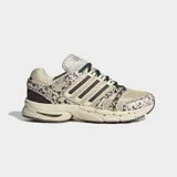 Championes Adidas Adistar Control 5 de estilo running retro, con exterior de malla transpirable en tono beige y detalles con estampado animal print tipo dálmata o vaca en tonos marrones y blancos. Cuenta con las clásicas tres tiras laterales en marrón oscuro, cordones verdes y suela amortiguada.