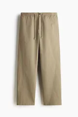 Pantalón relaxed fit en mezcla de algodón, de color beige, con cintura elástica ajustable mediante cordón, bragueta con botón y costuras decorativas giradas en las piernas.