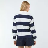 Camiseta oversize de manga larga a rayas horizontales azules y blancas, con cuello polo blanco.