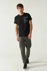 Pantalón cargo gris para hombre, de corte regular, con bolsillos laterales y traseros con solapa, pasacinto y logo metálico. Confeccionado en algodón y spandex.