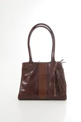 Bolso tote de cuero genuino color bordó con asas largas para hombro. Presenta una franja central con textura de cocodrilo y un adorno lateral de flecos.