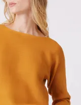 Buzo de silueta relajada confeccionado en tejido acanalado, con cuello redondo y mangas tres cuartos estilo japonés. Presenta un diseño fluido y cómodo.