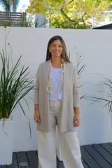 Saco tipo cárdigan abierto de corte recto y largo medio, color visón, con mangas largas y bolsillos frontales aplicados.