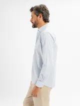 Camisa de manga larga con estampado de cuadros vichy en tonos celestes y blancos, con cuello abotonado.