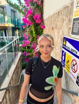 Top negro de microtul con estampado de orquídeas verdes.