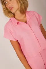 Camisa rosada de manga corta con cuello y corte holgado.