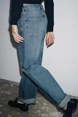 Pantalón de jean celeste de tiro medio, corte ancho y terminación con dobladillo.