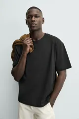 Camiseta de corte relajado confeccionada en algodón con textura irregular, cuello redondo y manga corta.