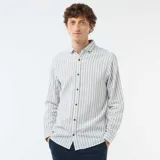 Camisa de manga larga confeccionada en mezcla de lino y algodón, con diseño de rayas verticales en tonos verde y blanco, cuello abotonado y cierre frontal de botones.