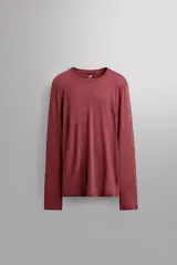 Camiseta térmica de manga larga color bordó, confeccionada en tejido elástico con lana, transpirable y termorreguladora. Presenta cuello redondo y es de la marca Zara Athleticz.
