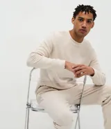 Pijama largo masculino Viko, confeccionado en fleece de color beige, sin estampado y con textura. Consta de una remera de cuello redondo y manga larga con puño ajustado, y un pantalón jogger con cintura elástica, cordón de ajuste y bolsillos.