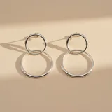 Aros colgantes de plata 925, compuestos por dos círculos entrelazados de diferentes tamaños con diseño bombé.