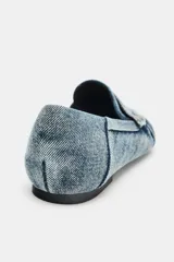 Mocasín plano confeccionado en efecto denim, con diseño de antifaz en el empeine, detalles fruncidos en la parte delantera y punta redonda.
