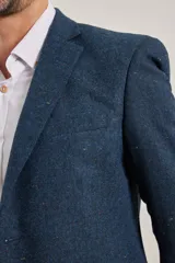 Blazer azul de corte slim, confeccionado en tejido con mezcla de lana. Tiene cuello con solapas, manga larga con puños abotonados, bolsillos de solapa en la cadera, abertura en la espalda y cierre frontal con botones.