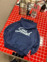 Hoodie azul marino de corte holgado con capucha amplia y estampado en la espalda con la palabra 'Ittab' en tipografía cursiva blanca.