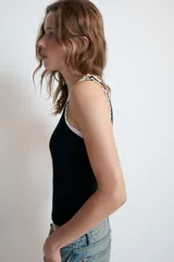 Top de algodón negro, sin mangas, con escote redondo y detalle de vivos a contraste en tejido tipo encaje blanco en el cuello y las sisas.