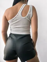 Top negro brillante de un solo hombro con abertura en el hombro izquierdo.