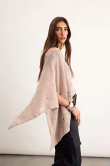 Poncho de lino tejido color tostado, con diseño asimétrico de punto abierto y mangas amplias.