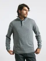 Sweater de punto color tostado, con cuello alto y cierre frontal parcial con botones. Diseño de manga larga con puños y ruedo acanalados.